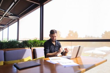 Miktar arazi kafeterya masada kağıtları ve dizüstü bilgisayar ile çalışma.
