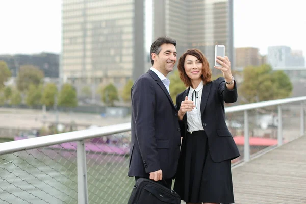 Marketer man and HR manager woman using smartphone taking sel