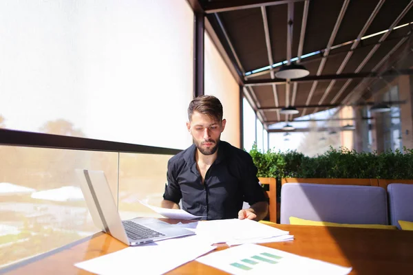 Papéis de classificação de funcionário de escritório na mesa perto do laptop . — Fotografia de Stock