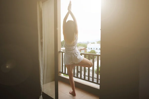 Jonge vrouw doet yoga op balkon hotel zonsondergang tijd — Stockfoto