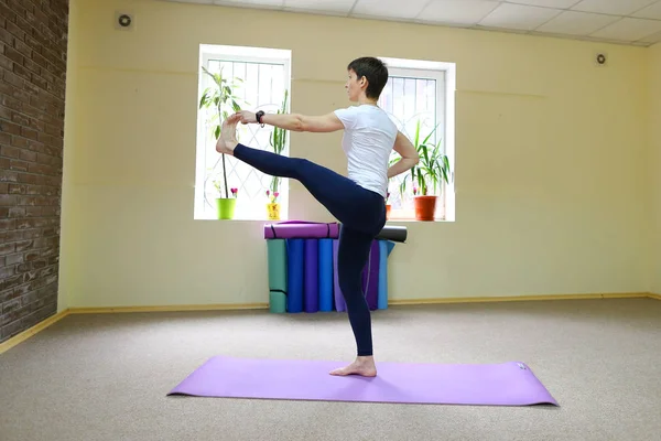 Mujer de aspecto europeo dedicada al yoga en gimnasio . — Foto de Stock