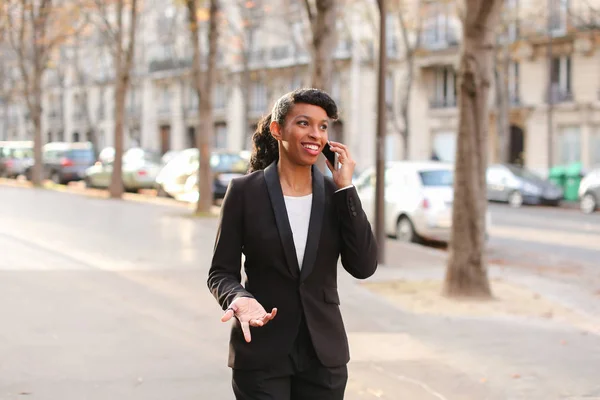 Travel administrator advising tours on smartphone in park.