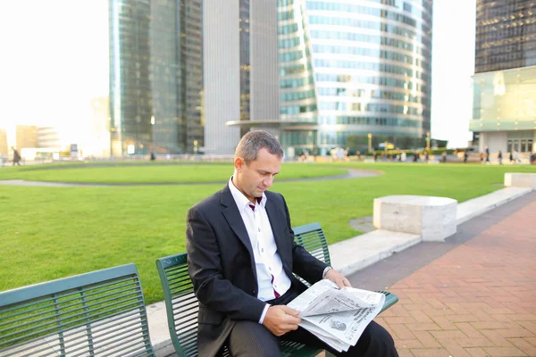 Mannelijke manager Gladden krant buiten in lezen  . — Stockfoto