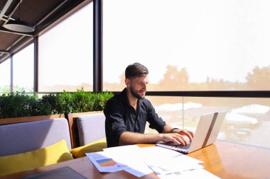 Tablo dizüstü yakınındaki kağıtlara sıralama ofis çalışanı.