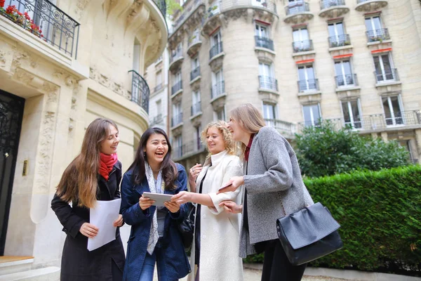 Professor talking with new students near university building in