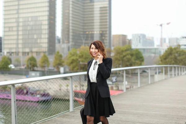 journalist woman in business clothes talking on smartphone