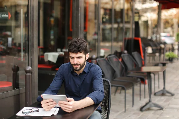 Hombre descontento jugando juego en línea por tableta en la cafetería de la calle . — Foto de Stock