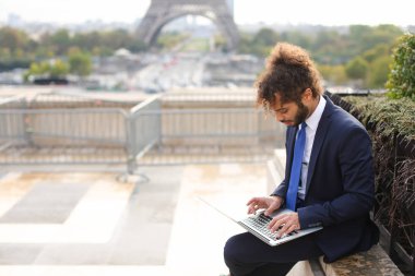 Karışık kan işadamı Eyfel Kulesi yakınındaki dizüstü bilgisayar ile çalışma