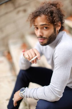 Genç sigara içen sigara ile basamaklarda öksürük.