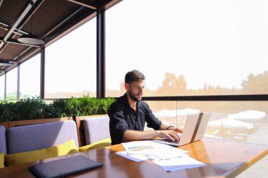 Miktar arazi kafeterya masada kağıtları ve dizüstü bilgisayar ile çalışma.