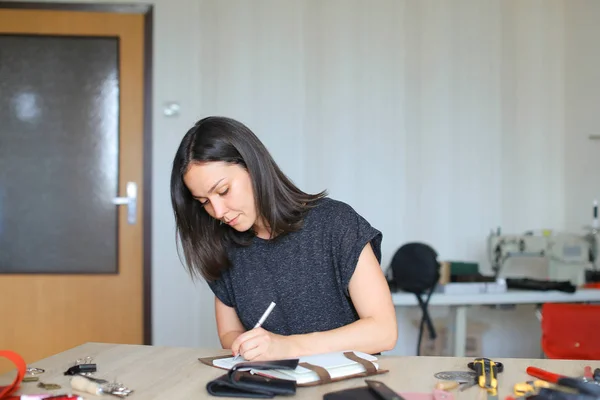 Female making belt to order.