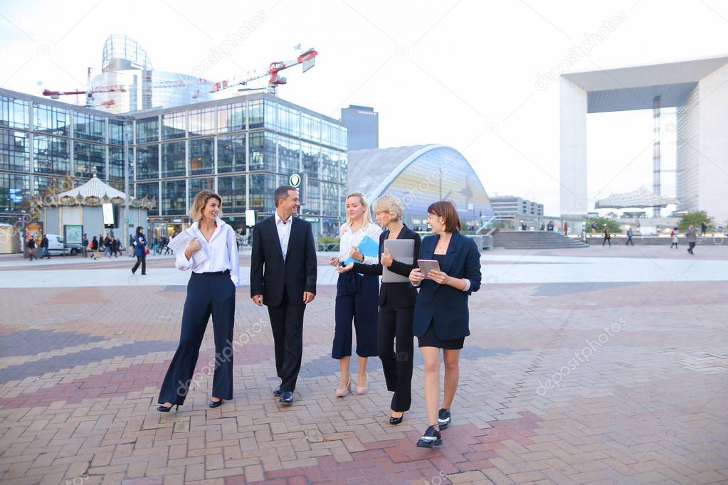 Employees of large corporation going with document case, laptop