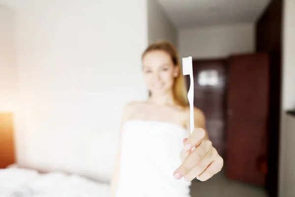 Focus op tandenborstel houden door jonge witte gelukkige vrouw — Stockfoto