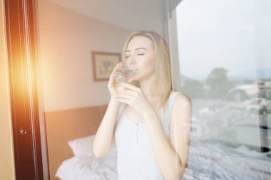 genç kadın su uyku modundan çıkarma sonra balkonda güneş ışığı ile içecekler