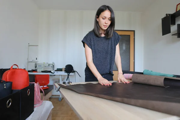 Girl using maternity leave to make leather accessories. — Stock Photo, Image