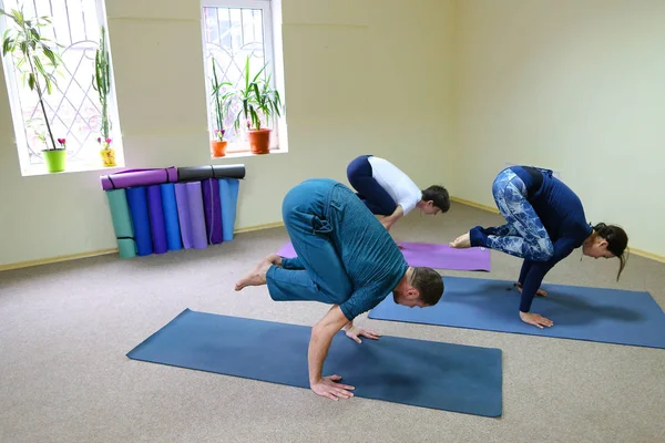 Young woman yoga trainer teaches the boy and girl to do the exer