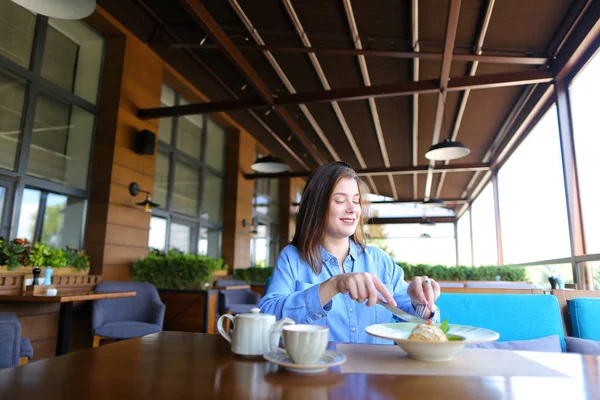 Satisfied girl eating dessert at restaurant  .