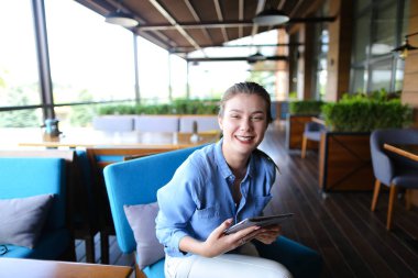 Güzel kız restoranda tablet ile çalışma  .