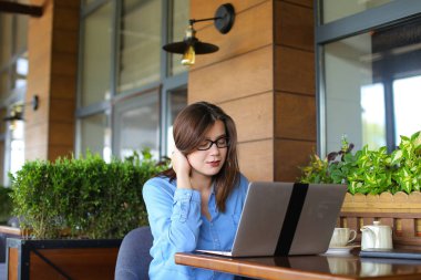 Kadın yazarı dizüstü restoranda makale yazmaya.