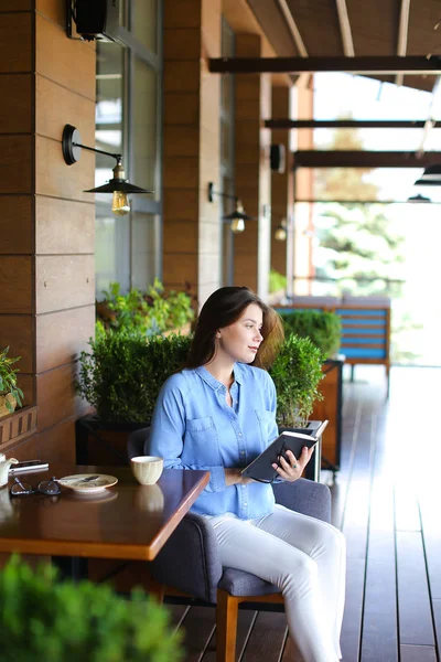 Hermosa chica leyendo diario en la cafetería   . — Foto de Stock