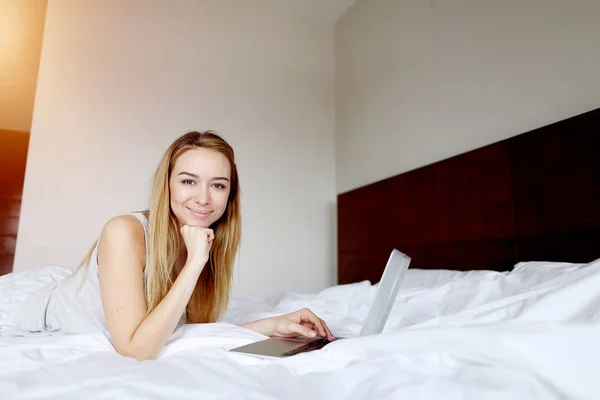 Retrato de la mujer trabajadora feliz con el ordenador portátil de forma remota en casa cama blanca — Foto de Stock