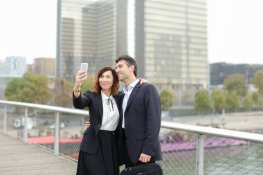 Pazarlamacı erkek ve İK Yöneticisi kadın sel alarak smartphone kullanarak