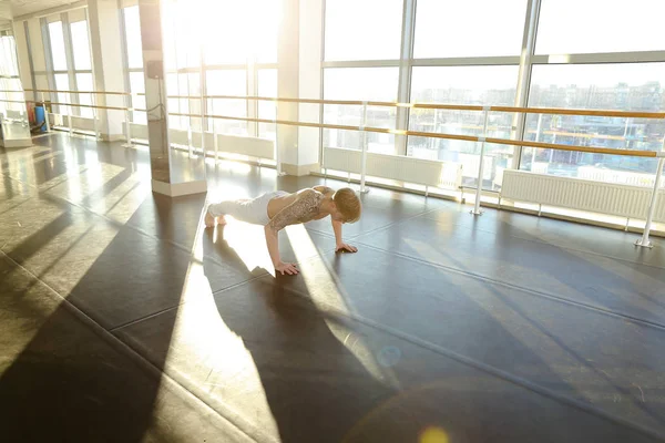 Marketer in sportswear practice physiotherapy in spacious gym