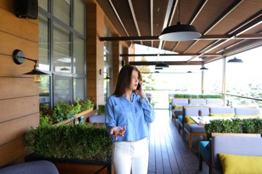 Güzel kadın modeli smartphone tarafından fotoğrafçı ile konuşma