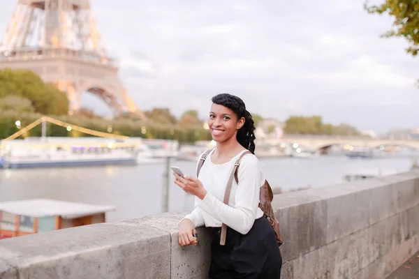 Sorrindo mulher de negócios de pé na ponte e usando smartphone — Fotografia de Stock