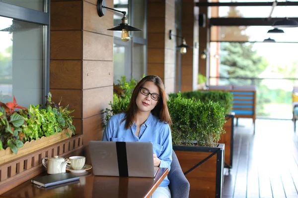Красивая девушка просматривает ноутбук в кафе . — стоковое фото