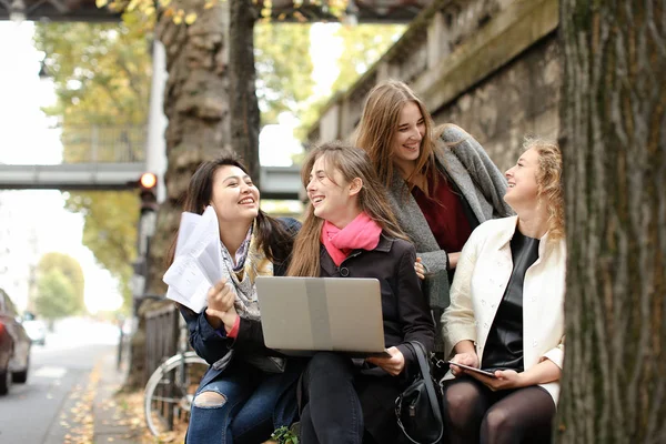 Étudiants européens apprenant avec ordinateur portable et papiers, assis sur être — Photo