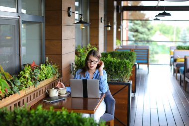 Smartphone ile konuşmak ve laptop ile café'de çalışan serbest meslek