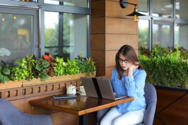 Smartphone ile konuşmak ve laptop ile café'de çalışan serbest meslek