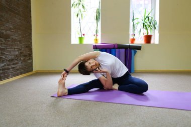 Güzel kız yapıyor germe egzersizleri ve yoga asanas.