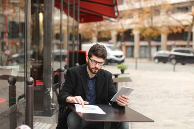 Diyagram ve tablet çalışma istatistikçi kafeterya masada .