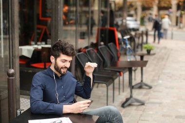 Amerikalı çocuk Café earphones ve akıllı ile müzik dinlemek