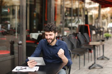 Hoşnutsuz adam online oyun tarafından tablet sokak café'de oynuyor..