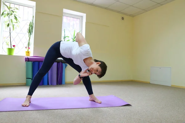 Mujer de aspecto europeo dedicada al yoga en gimnasio . — Foto de Stock