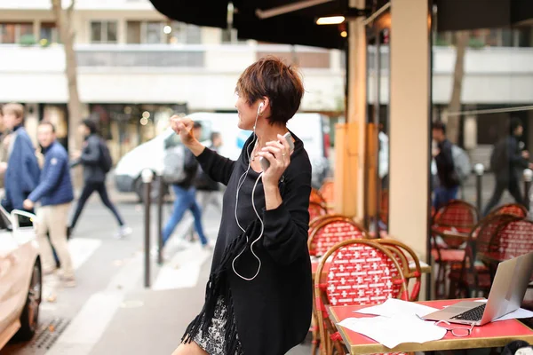Turista mujer de mediana edad escuchar música por teléfono inteligente y danci — Foto de Stock
