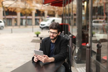 Online poker oyuncusu kafeterya masada tablet kullanma  .