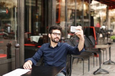 Amerikalı çocuk Café earphones ve akıllı ile müzik dinlemek