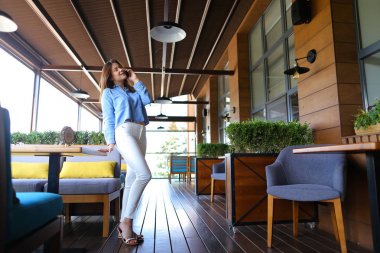 Genç kız yanında smartphone restoranda konuşuyor  .