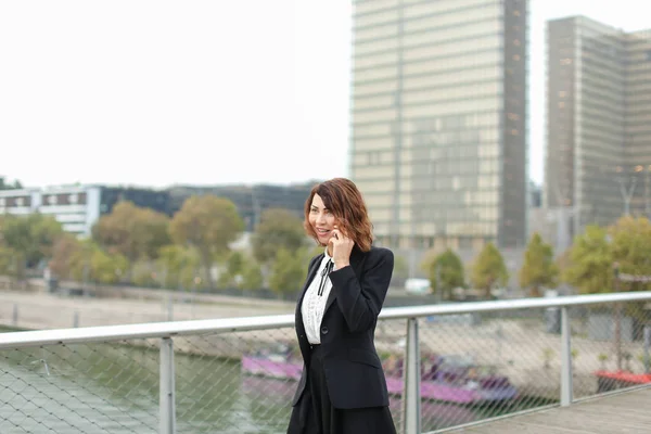 Jornalista mulher em roupas de negócios falando no smartphone — Fotografia de Stock