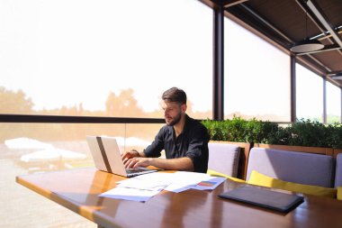 Başarılı foreman kafede dizüstü ve belgeleri kullanma.