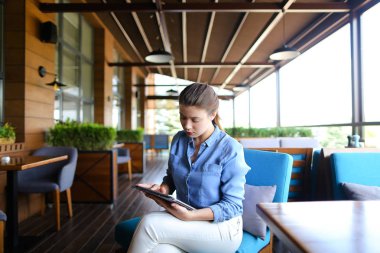 Güzel kız restoranda tablet ile çalışma  .
