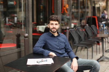 Gazeteci ile yakın çekim yüz gazete makalesi kafede okuma