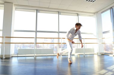 Adam beyaz elbiseli tektonik tarzda dans.