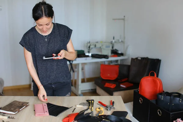 Girl taking pictures of handmade notebook using smartphone.