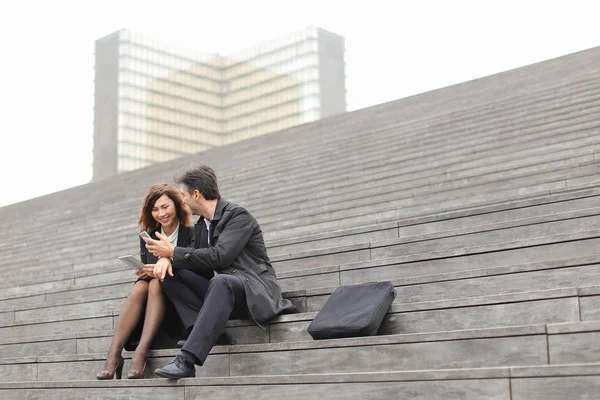Manželský pár obchodních učitelé pomocí tabletu a smartphon — Stock fotografie