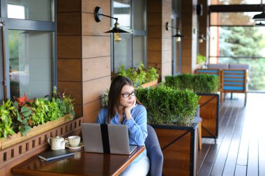 Güzel kız kafede dizüstü bilgisayar tarama.